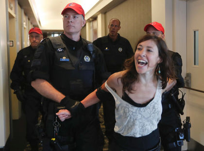 A protester is removed from the conference centre where Montreal mayor Denis Coderre was scheduled to speak at the National Energy Board public hearings into the Energy East pipeline project, starting in Montreal in Monday, August 29, 2016. Coderre left without speaking. (John Kenney / MONTREAL GAZETTE)